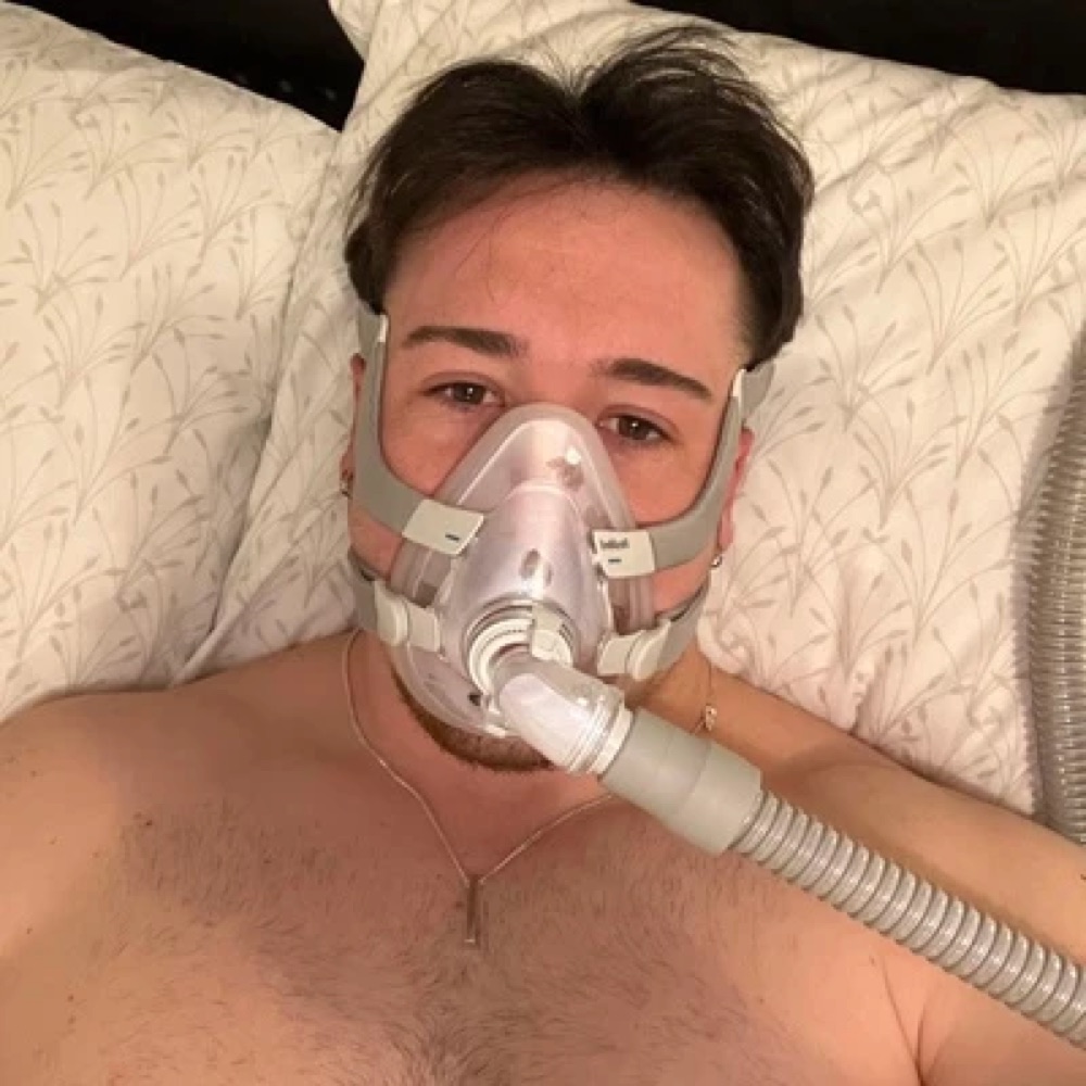 Adam wearing a CPAP mask in bed