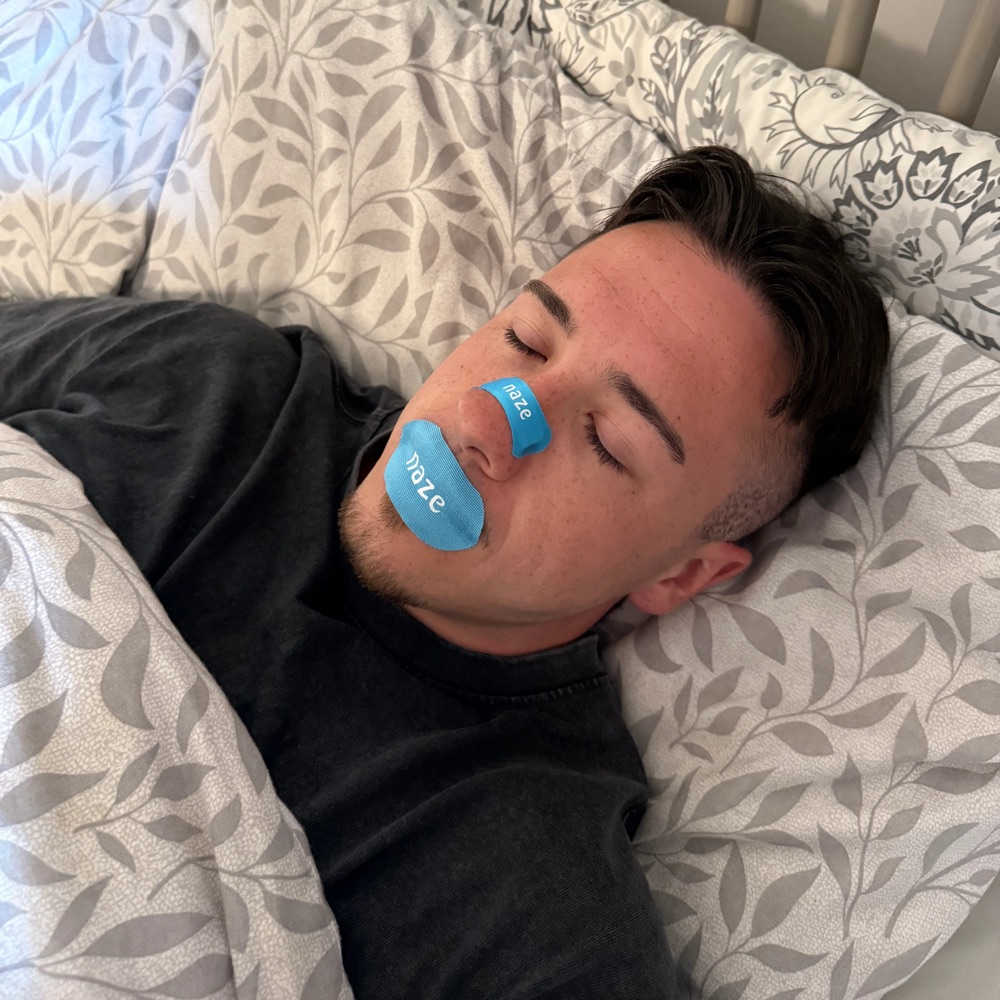 Adam asleep wearing Naze tape and a Naze strip